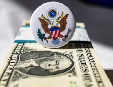 A white button sitting on top of a one dollar bill