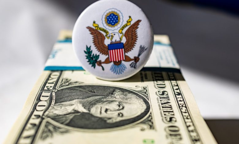 A white button sitting on top of a one dollar bill