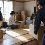 In a compact apartment’s tatami room crowded with seasonal belongings, one renter kneels beside an opened
