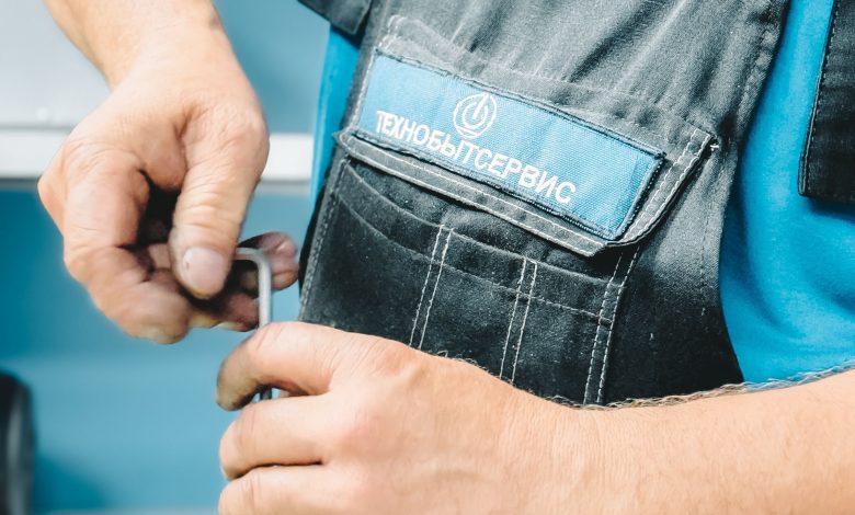 Plumber working on a pipe connection indoors.