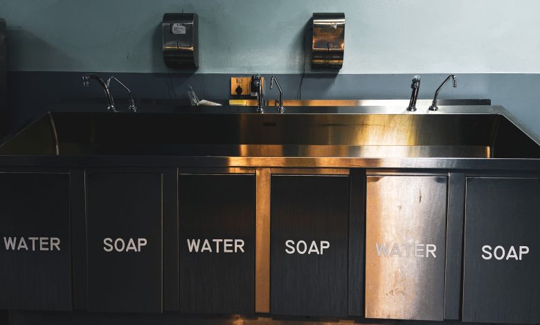 Stainless-steel sink and plumbing fixtures in a commercial kitchen.