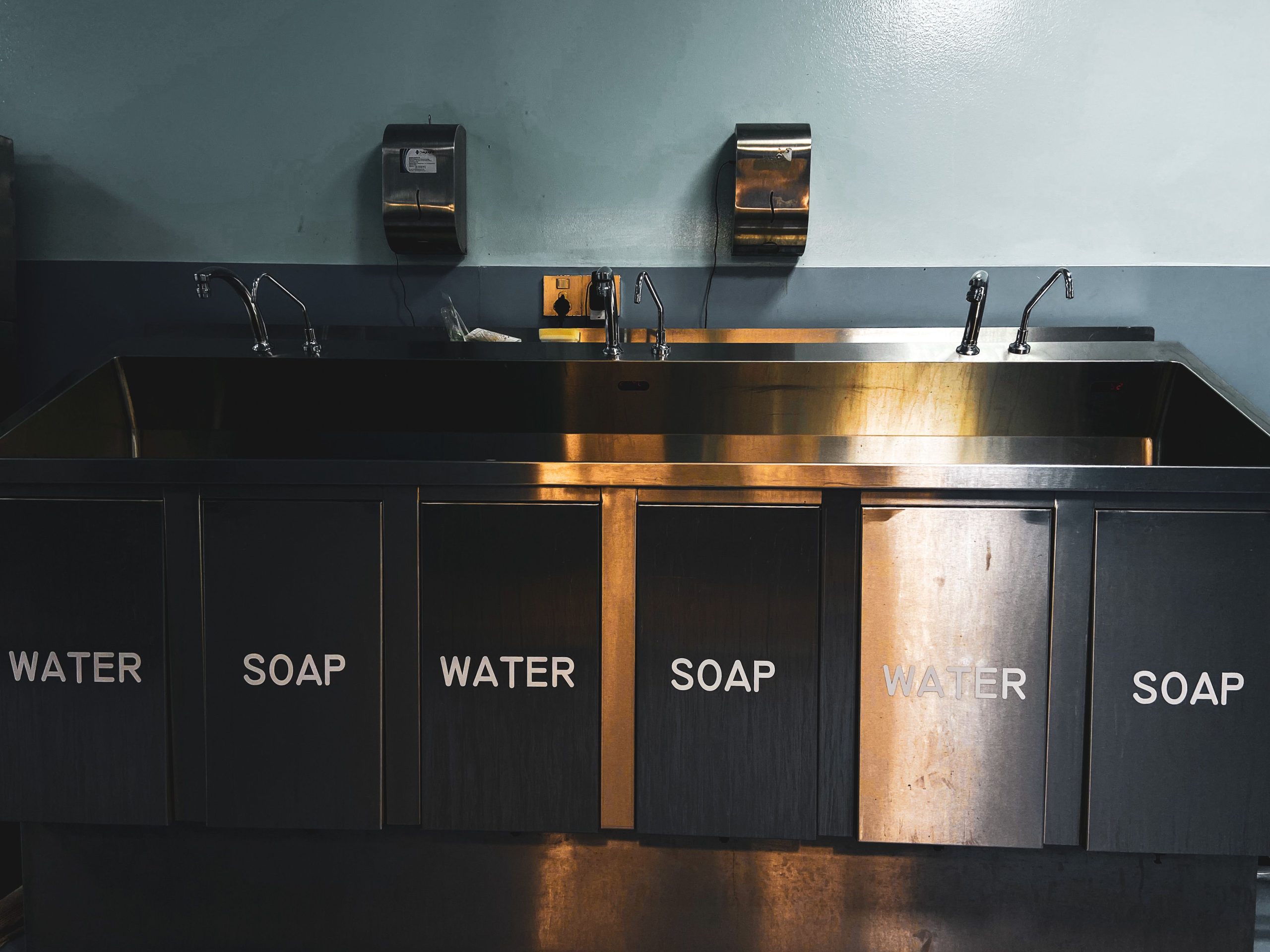 Stainless-steel sink and plumbing fixtures in a commercial kitchen.