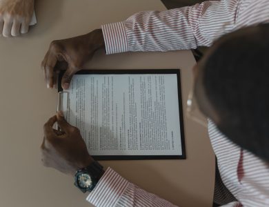 A close-up, overhead view of an individual holding a document during a business meeting.