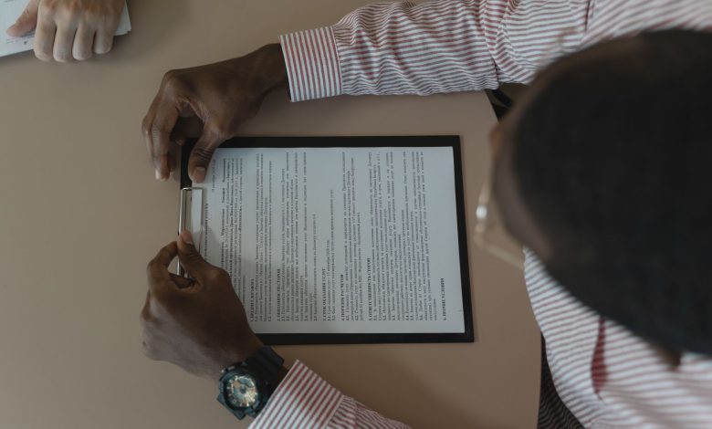 A close-up, overhead view of an individual holding a document during a business meeting.