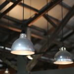 Close-up view of industrial hanging lamps in a warehouse setting.