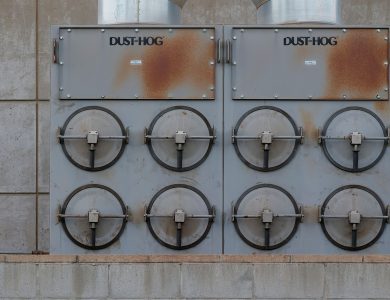 Close-up of a Dust-Hog industrial dust collector with six rusty filtration units.