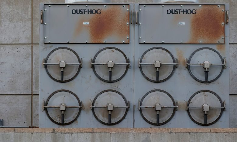Close-up of a Dust-Hog industrial dust collector with six rusty filtration units.