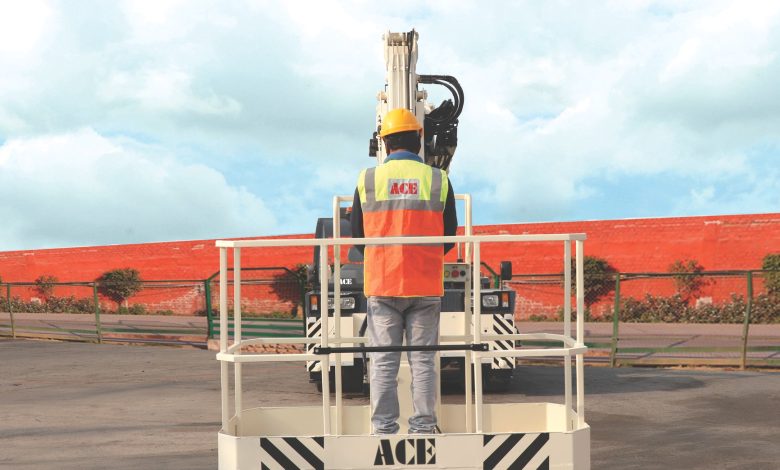 A worker in safety gear operates an ACE man lift crane, showcasing industrial safety in an outdoor setting.