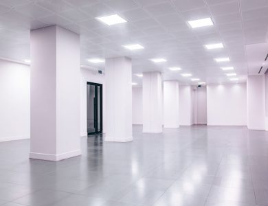 Wide-angle view of a modern minimalist white office space with clean lines and ample lighting.