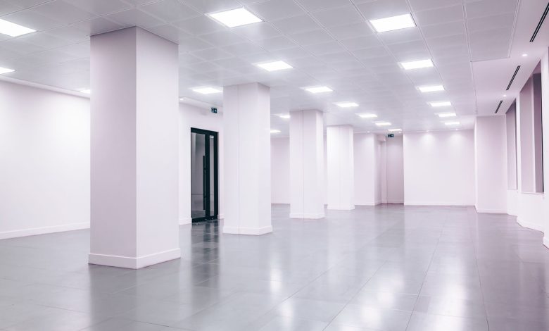 Wide-angle view of a modern minimalist white office space with clean lines and ample lighting.