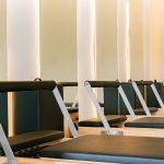 Interior of a modern Pilates studio featuring multiple reformer machines in a calming atmosphere.