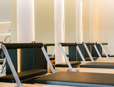 Interior of a modern Pilates studio featuring multiple reformer machines in a calming atmosphere.