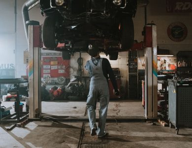 Automobile mechanic fixing a car in a repair garage, focus on service and repair work