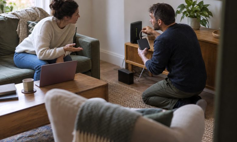 Two homeowners who work from home are in their terraced-house living room during a broadband outage,