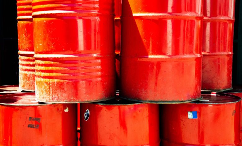 Bright red industrial oil barrels stacked outdoors in daylight, showcasing vivid color and industrial theme.