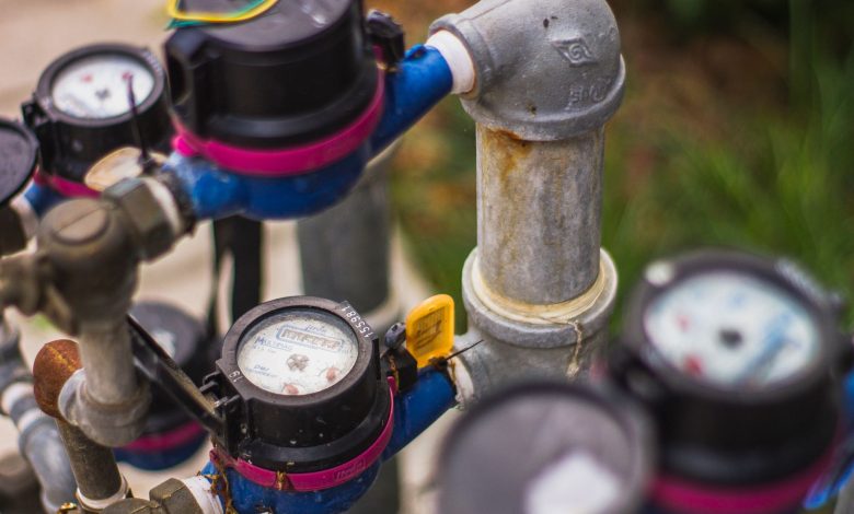 Detailed image of industrial water pressure gauges and pipes in an outdoor setting.