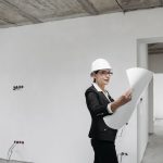 Professional female architect examining construction plans in a modern building