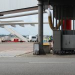 Airport scene depicting aircraft preparation on the tarmac with maintenance equipment.