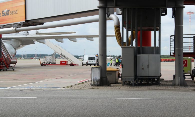 Airport scene depicting aircraft preparation on the tarmac with maintenance equipment.