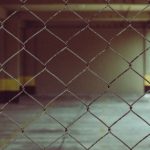 Blurred interior view through a chain link fence in industrial setting.