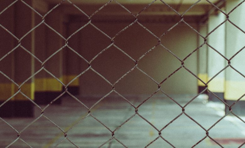 Blurred interior view through a chain link fence in industrial setting.