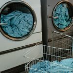 Industrial washing machines with blue towels in a laundry facility.