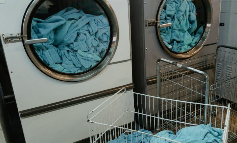 Industrial washing machines with blue towels in a laundry facility.