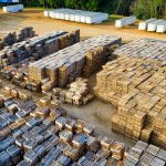 An aerial view of stacked wooden pallets in a warehouse yard, showcasing industrial storage arrangement.