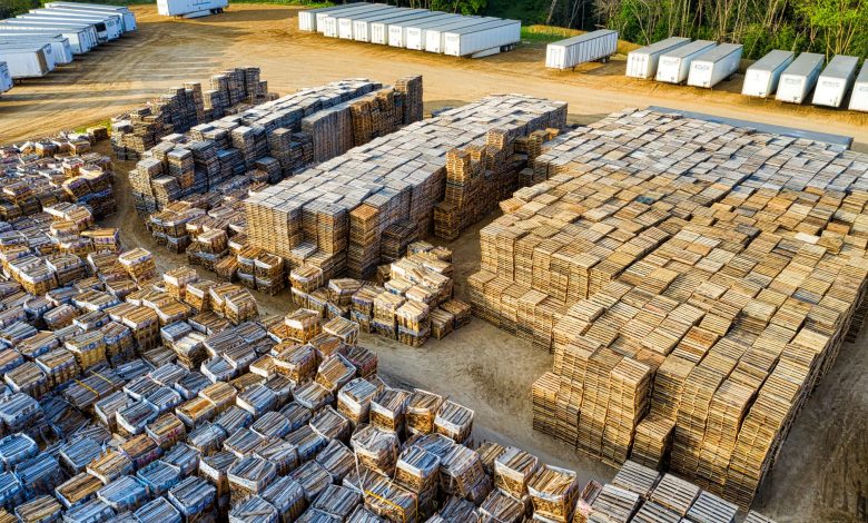 An aerial view of stacked wooden pallets in a warehouse yard, showcasing industrial storage arrangement.