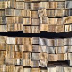 High angle shot of neatly stacked wooden pallets in an outdoor warehouse setting.