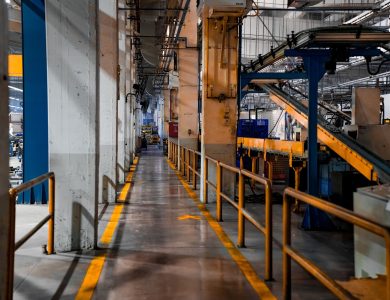Wide view of a modern factory interior showcasing industrial machinery and conveyor systems.