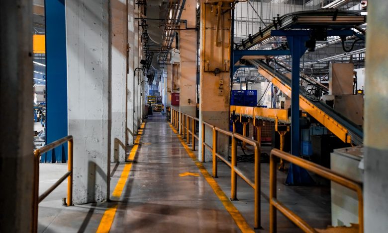 Wide view of a modern factory interior showcasing industrial machinery and conveyor systems.