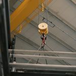Close-up view of a yellow overhead crane hook in a warehouse in Konya, Türkiye.