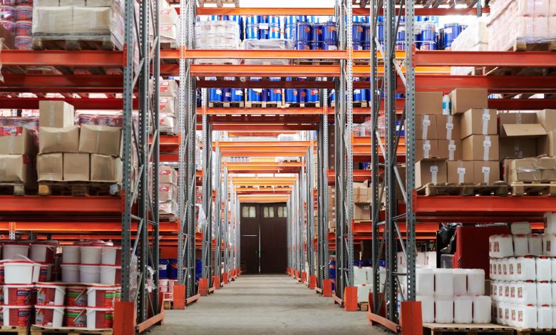 Wide angle view of a warehouse with stocked shelves and boxes.